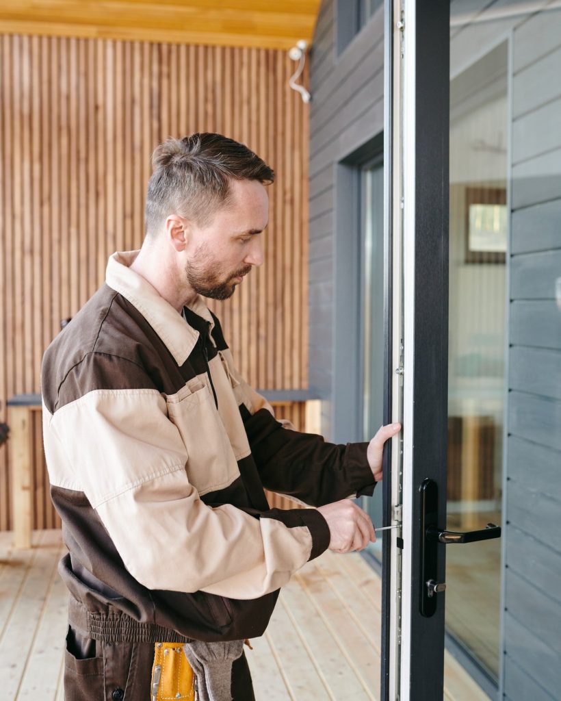 repairman fixing lock in large transparent door